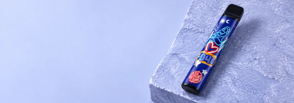 187 Vape mit blauem Motiv, diagonal auf einer Steinbühne